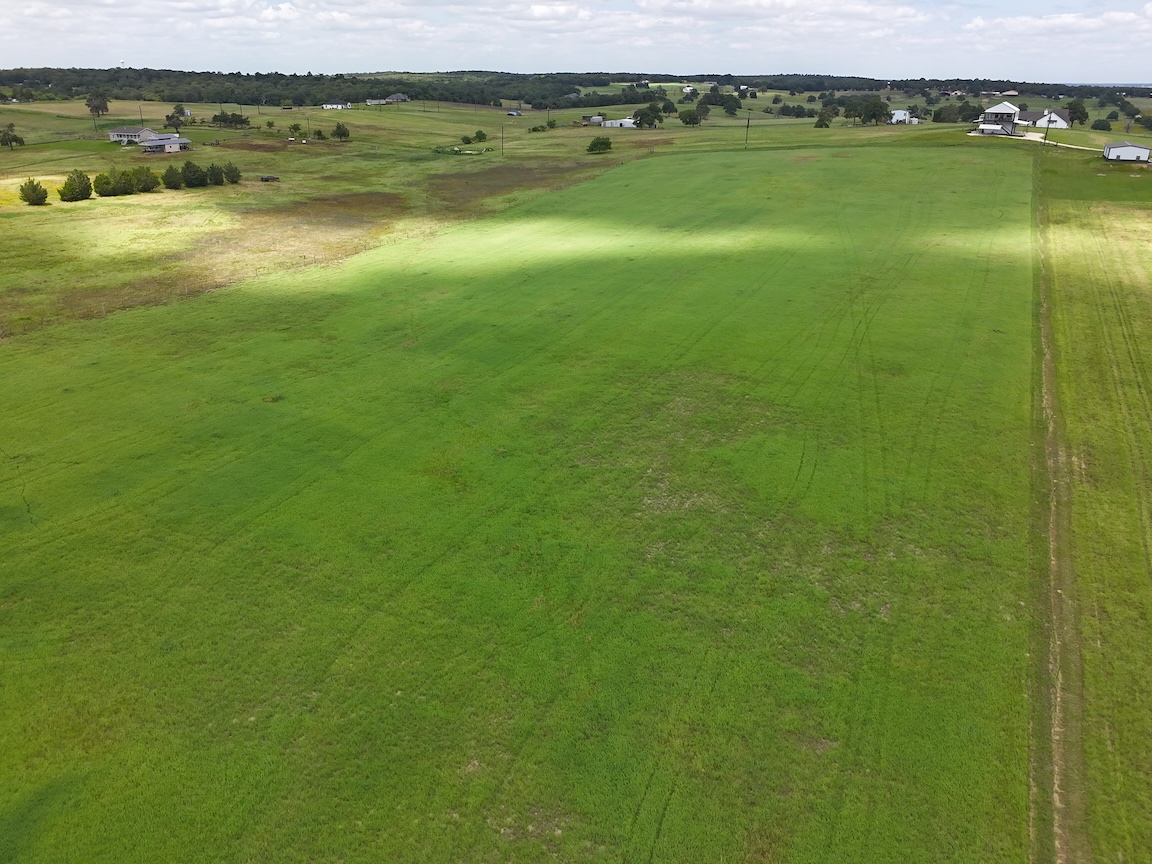 Drone view looking across the property toward the tree line